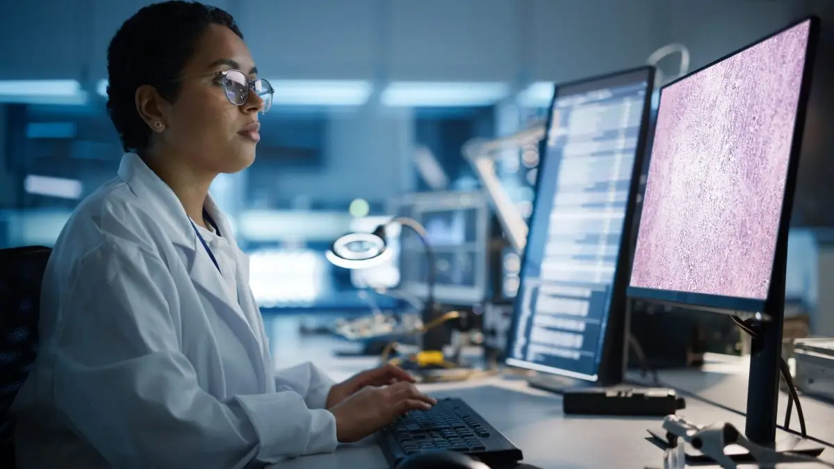 Modern Electronics Development Facility: Female Engineer Works on Computer with CAD Programming Software. Scientists Design of Industrial PCB, New Generation Silicon Microchips, Semiconductors